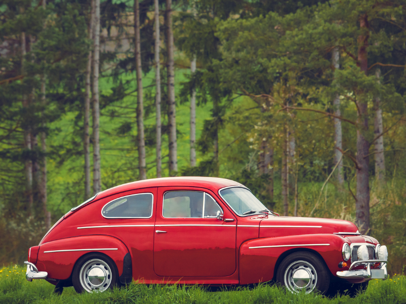 A vintage car sits on the grass.