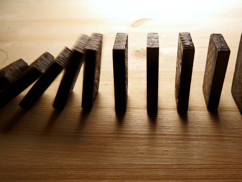 Dominoes topple on a table.