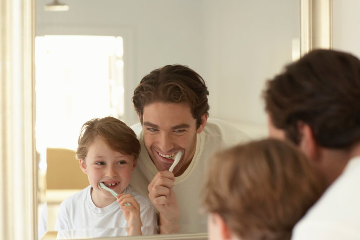 Family brushing teeth together