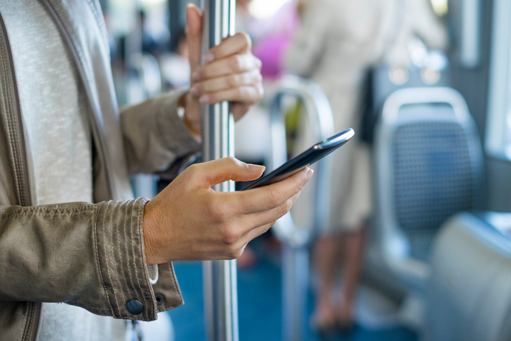 Woman on bus with cell phone