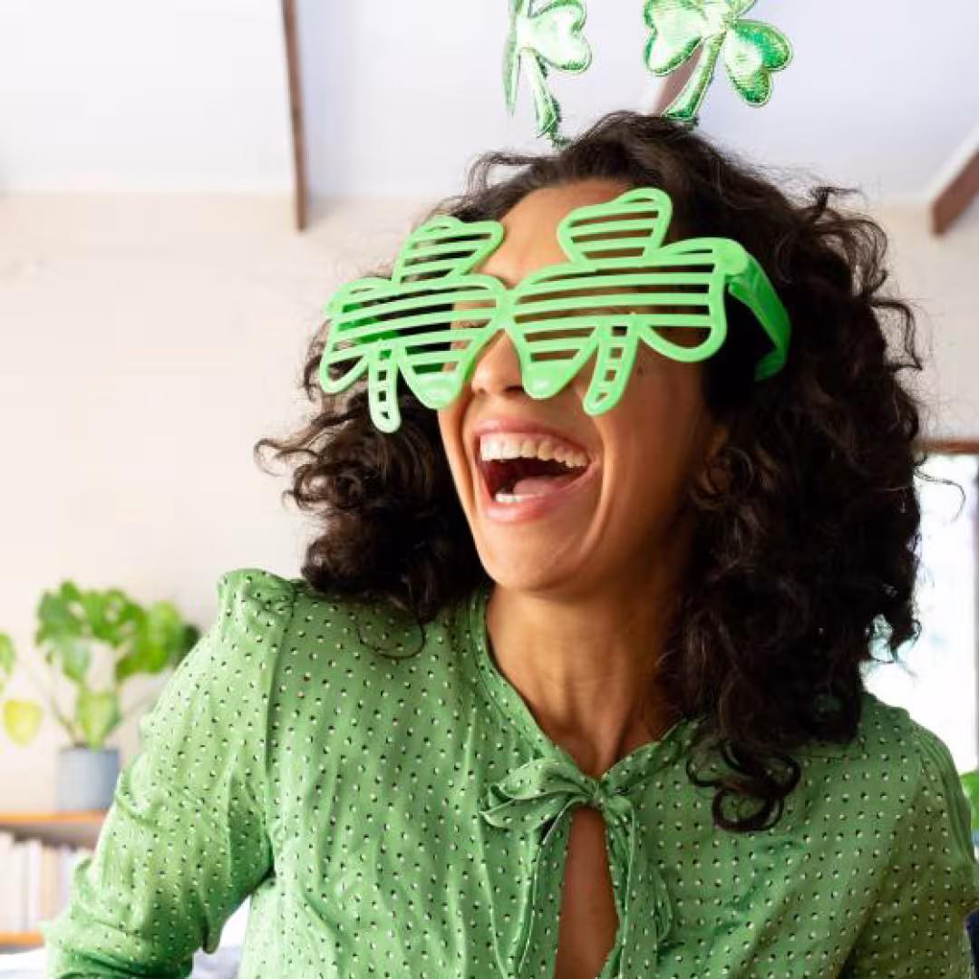 Woman with clover leaf glasses looking excited