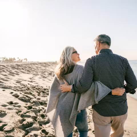 Older couple walking on beach