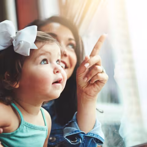 Mother with toddler looking out window