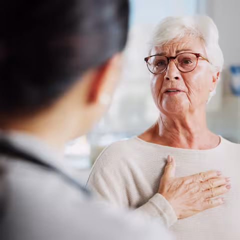 Consulting, chest pain and healthcare with old woman and doctor