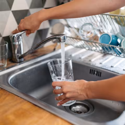 Young Woman Filling A Glass Of Water In The Sink