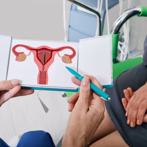 gynecologist showing female patient intrauterine contraceptive device or coil to prevent pregnancy while consultation