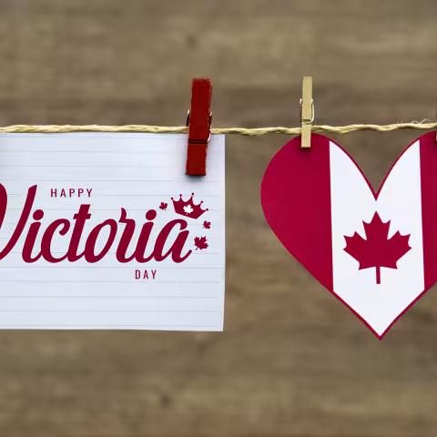 Clothes line with a sign pinned to it that reads "Happy Victoria Day" and a Canadian flag heart beside it.