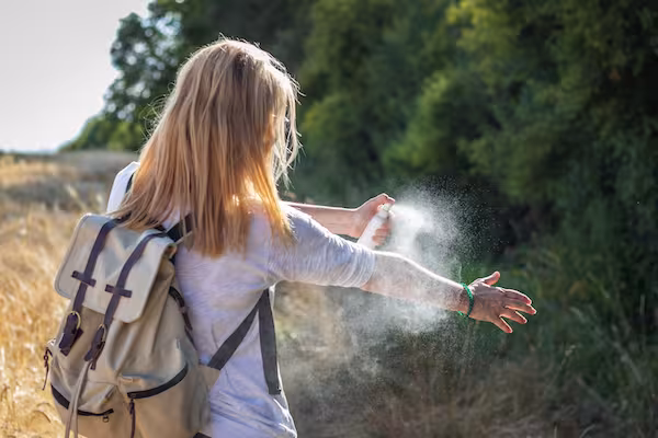 girl applying bug spray