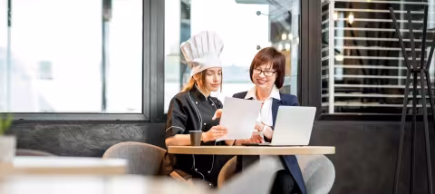 Two restauranteurs reviewing a menu together