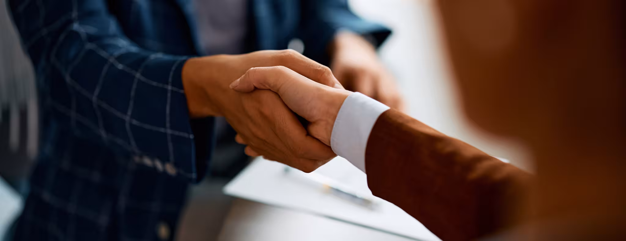 Close up of business people shaking hands in the office.