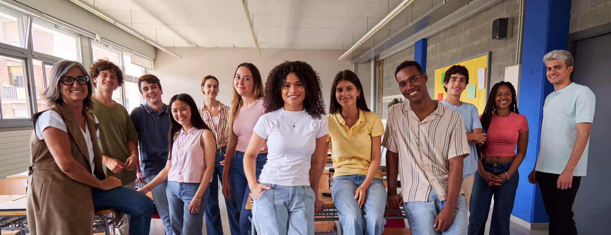 Cheerful group of high school students in classroom
