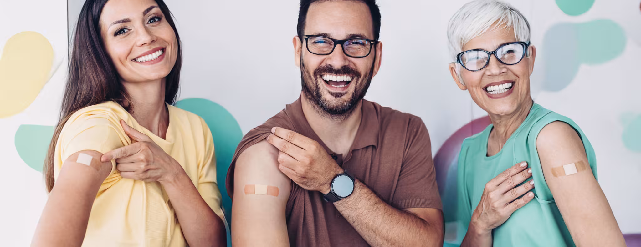 Child care workers pointing at bandaids on their arms