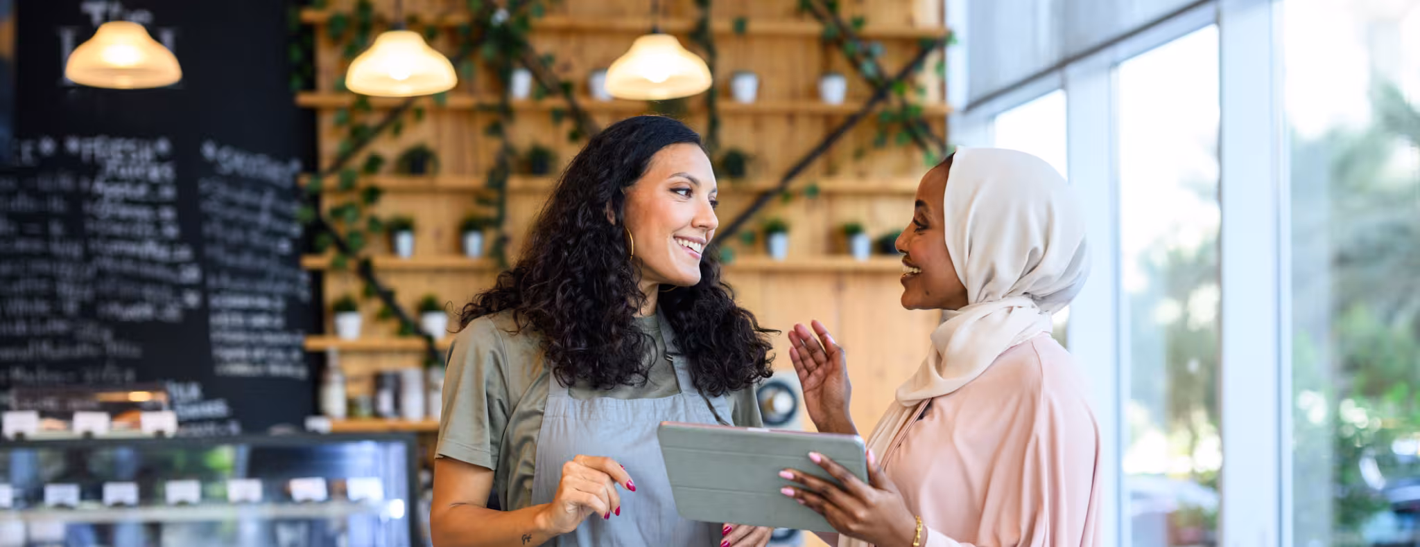 Two diverse women discussing small business strategy in a cafe 