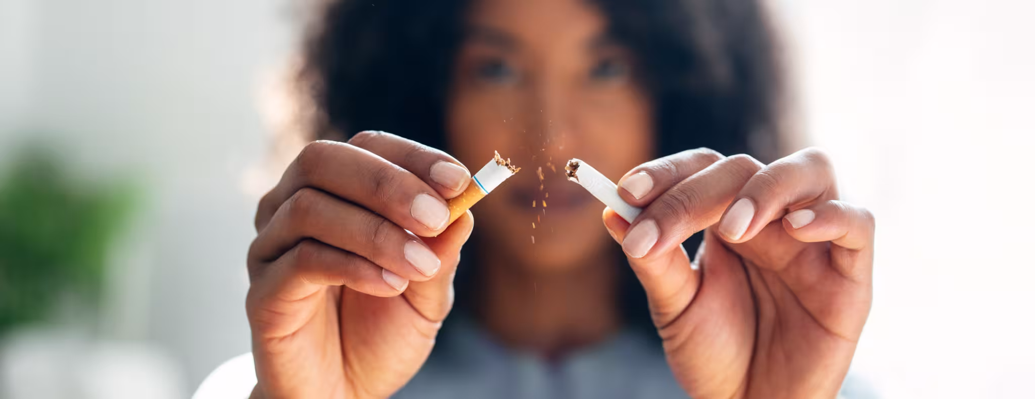 Woman breaking down cigarette to pieces. Quit smoking concept